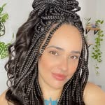 Mulher parda com tranças, tatuagem no peito